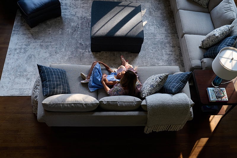 Mother and child cuddling on a couch in their home