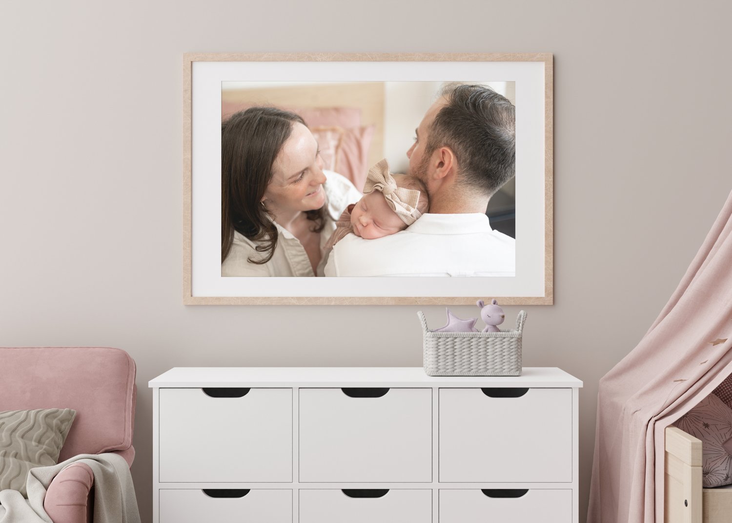 Large-format family photo displayed on the wall of a baby's nursery.