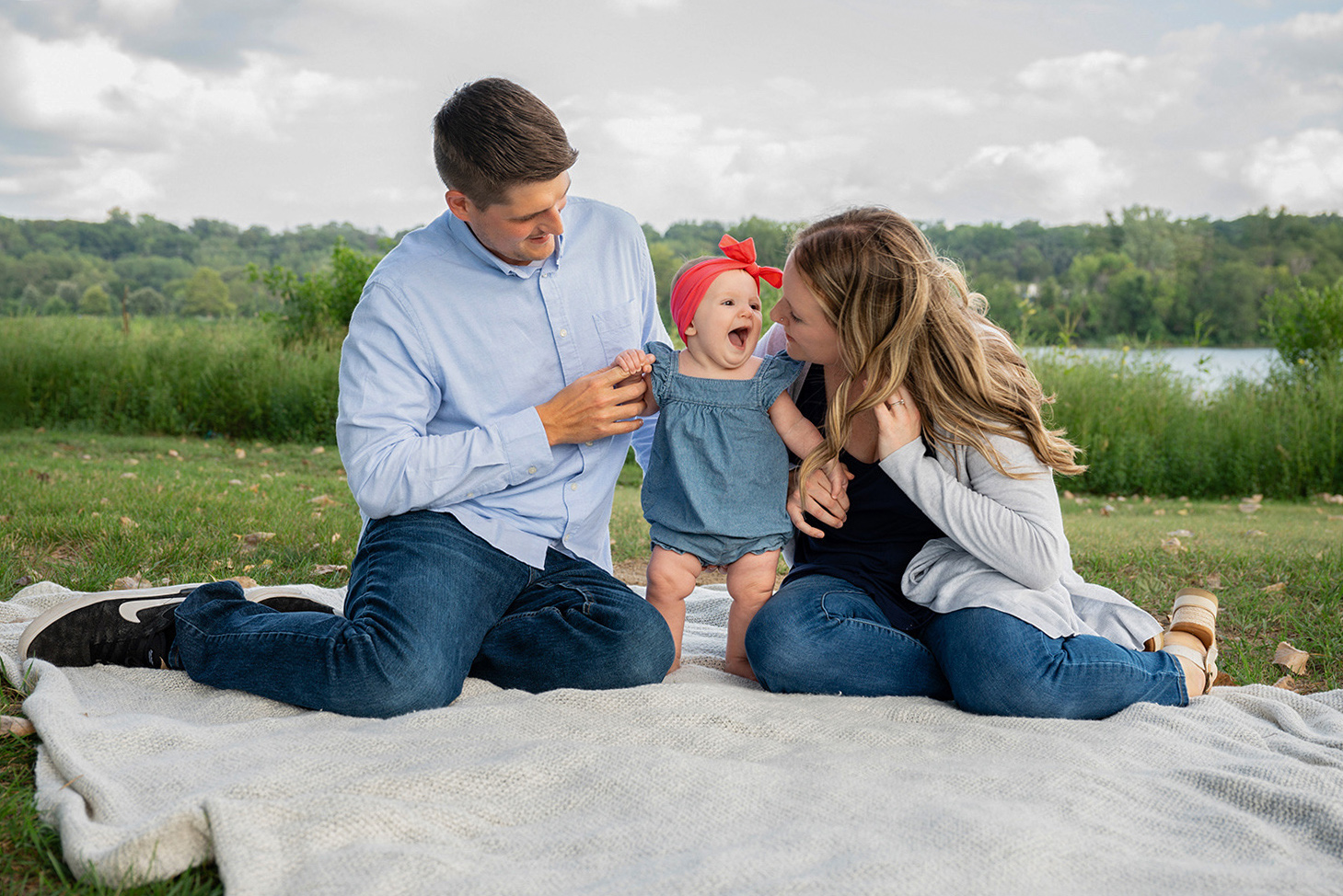 Family dressed in mixed but complementary textures, including knits, denim, cotton, and a textured blanket.
