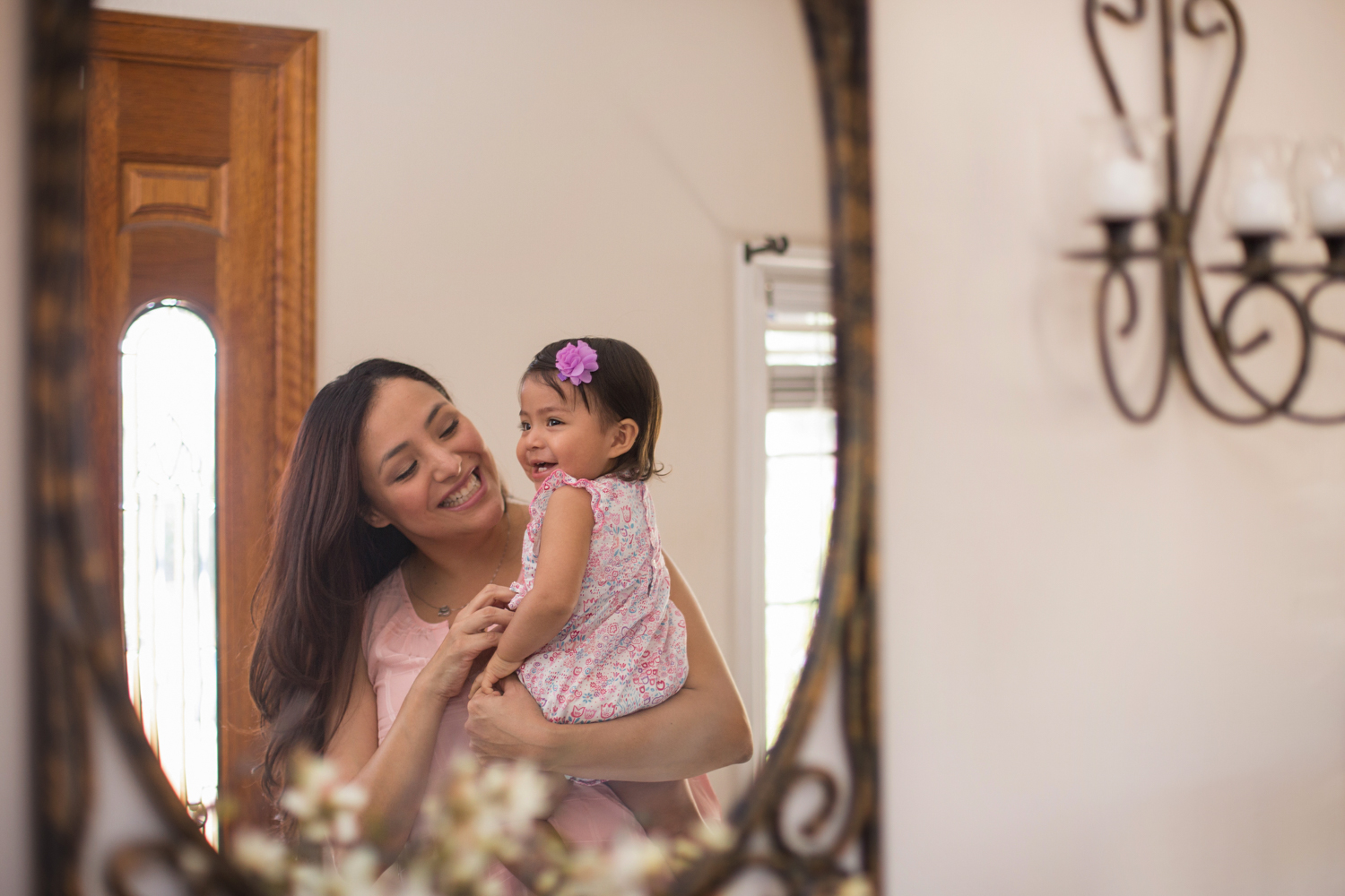 Mother and child looking in a mirror.