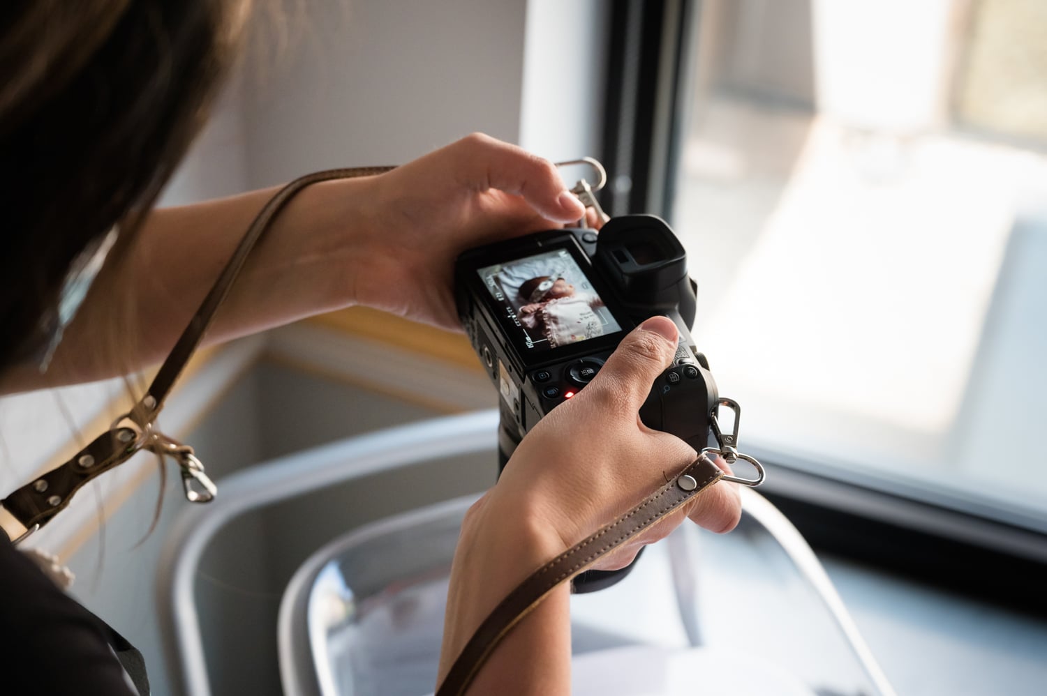 Behind-the-scenes view of a Bella Baby photographer capturing images during a session.