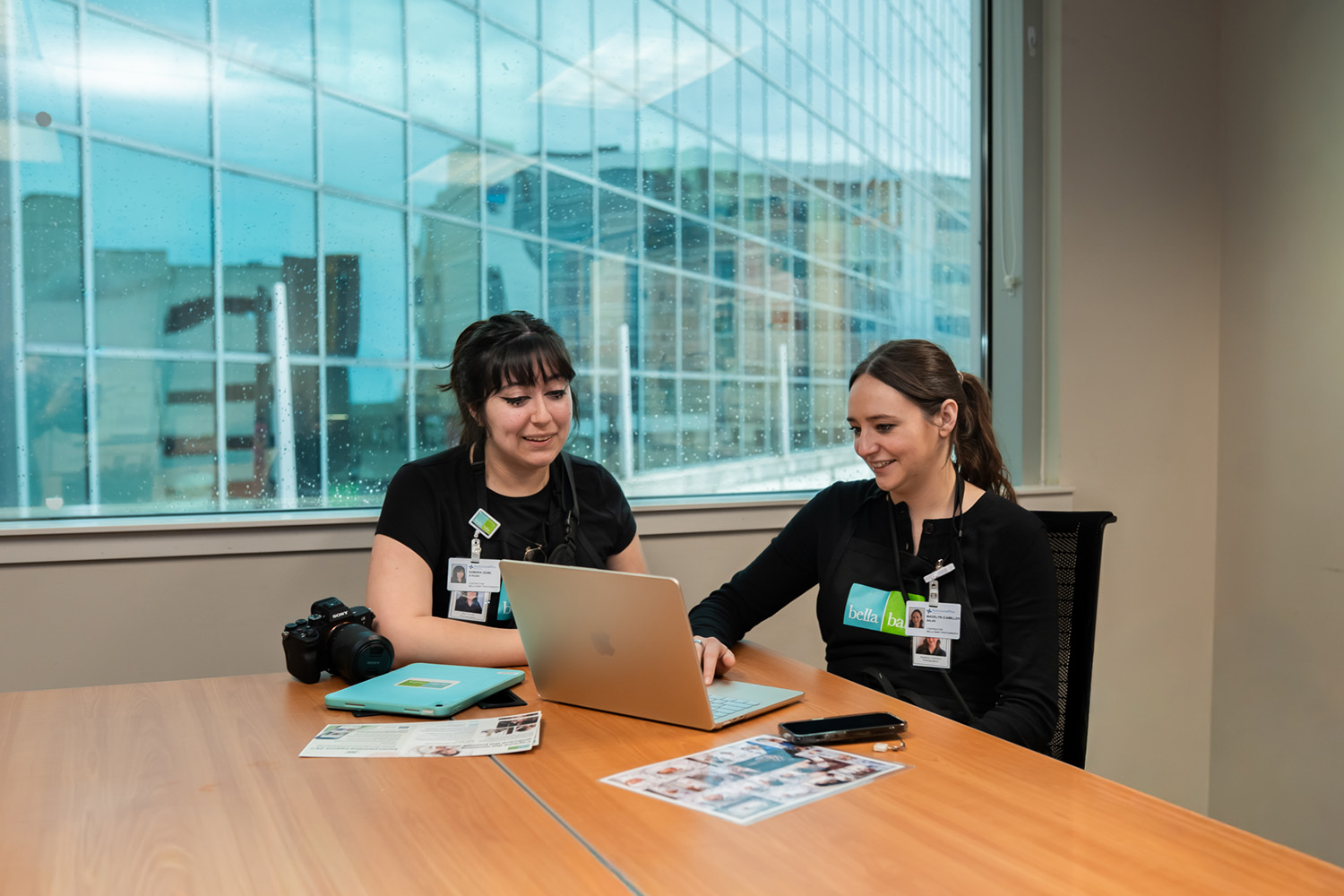 Two Bella Baby photographers looking at a laptop