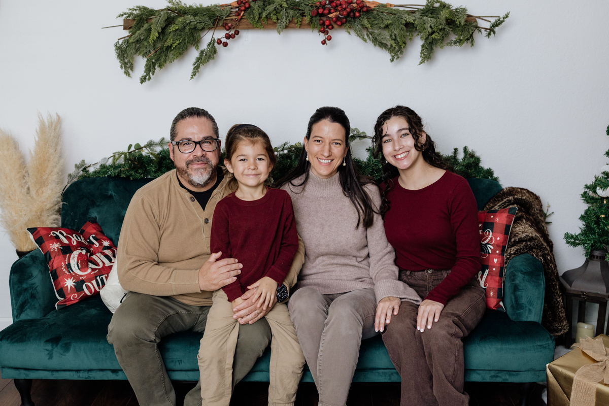 Family seated on a couch during a Christmas themed photoshoot
