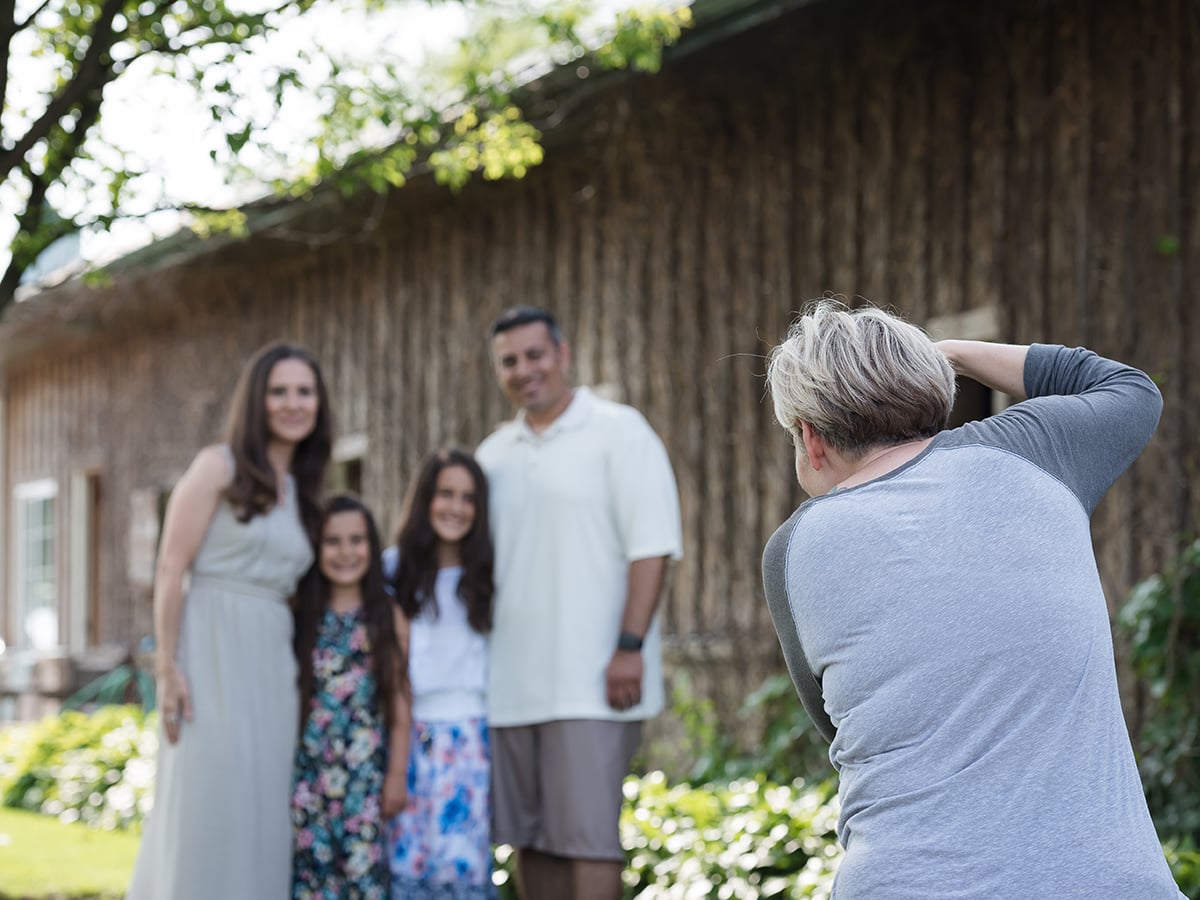 A Bella Life photographer photographing a husband, wife, and their two daughters